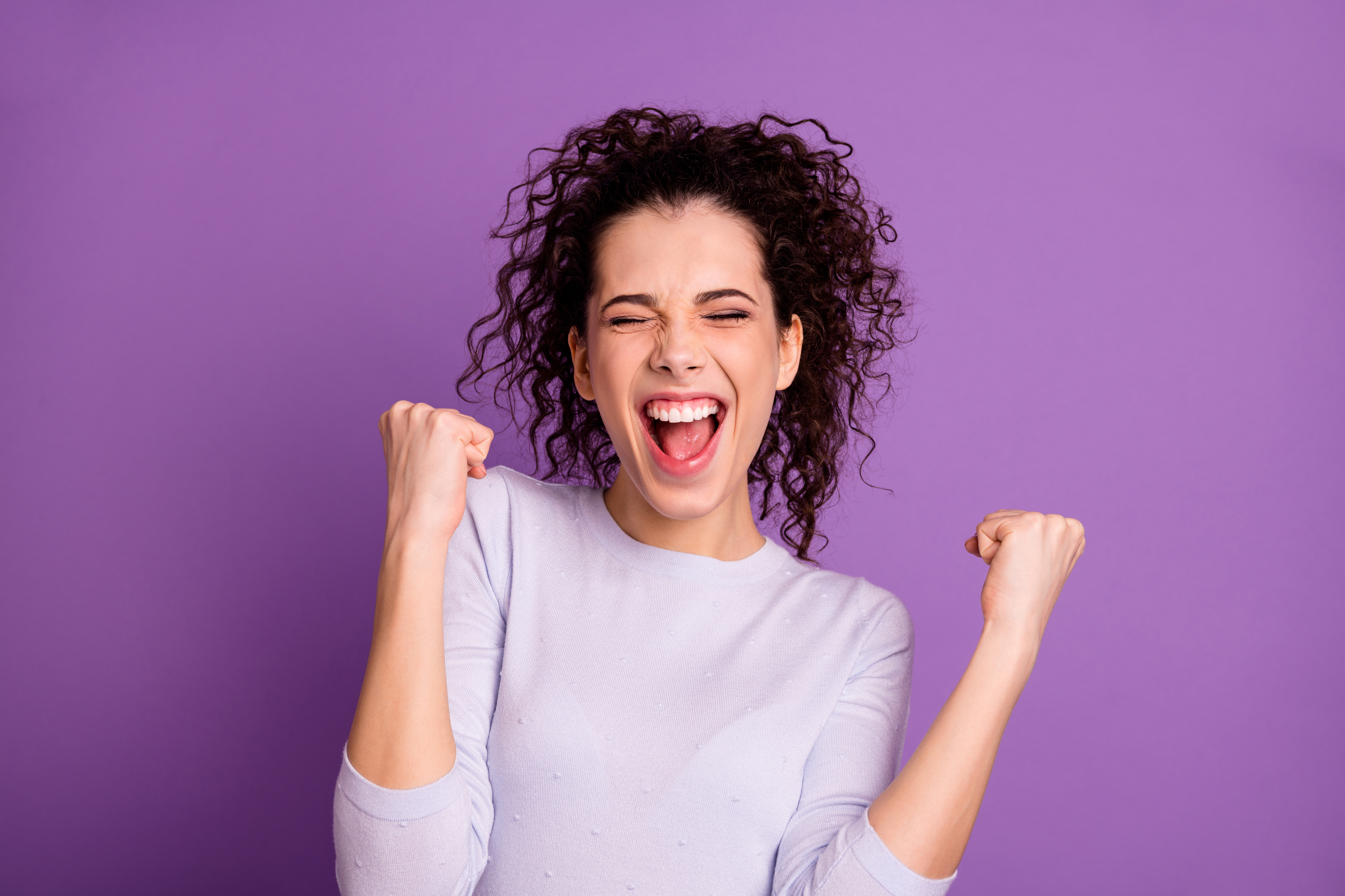 Woman celebrating with eyes closed and fists in the air