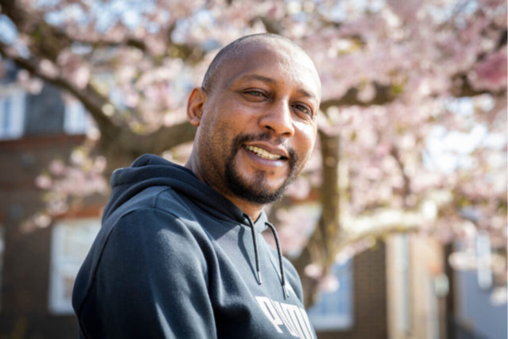 A man outside with tree blossom