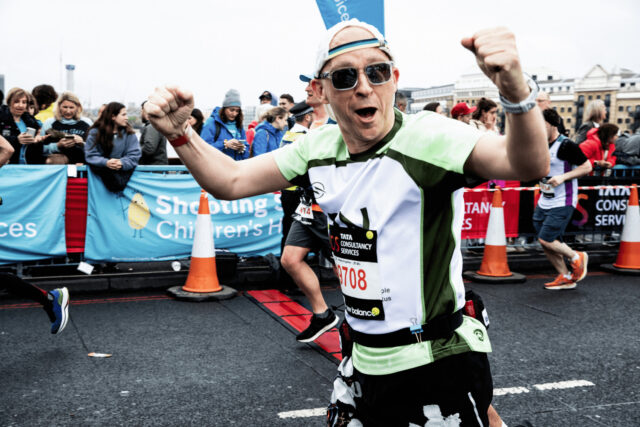 A London Marathon runner cheering and wearing an RNID t-shirt.