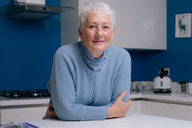 Woman leaning on a kitchen unit and smiling