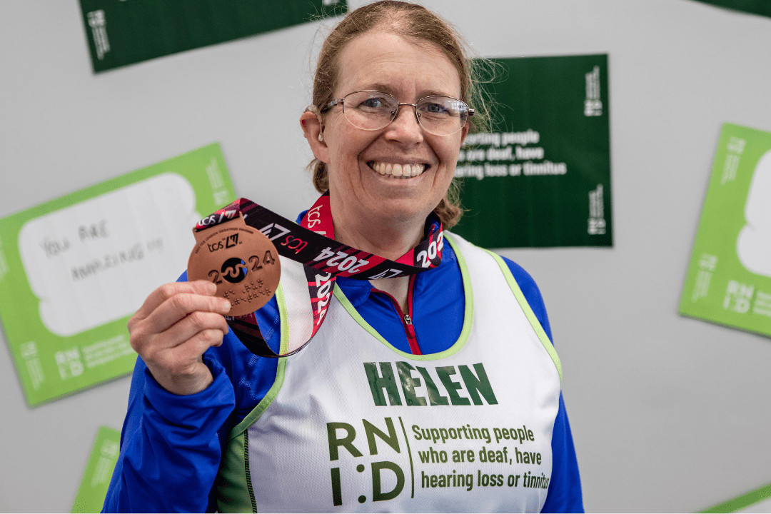 Helen, a 2024 race runner holding her medal and smiling