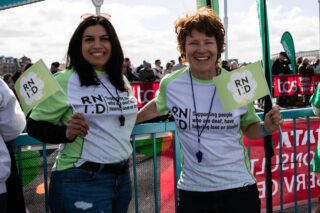 Two people with RNID Tshirts on helping out at a running event