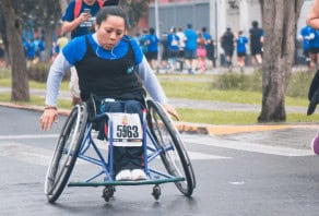 A woman completing a running race in her wheelchair