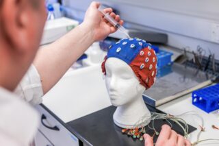 A research scientist working with a model head in a laboratory.