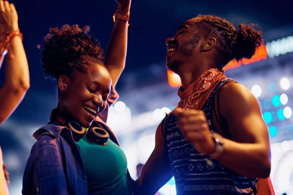 Two people dancing at a festival wearing hearing protection