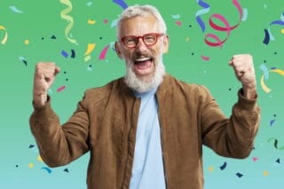 A man cheers happily as confetti falls around him.