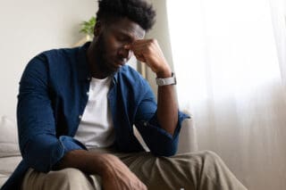 A man sits with his head in his hands.